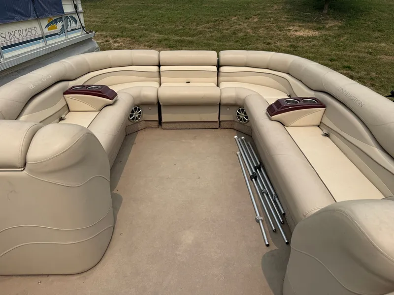 Slide: The Image of The image shows the spacious, beige-upholstered seating area of a 2010 Bennington 2550 RCW. - 10