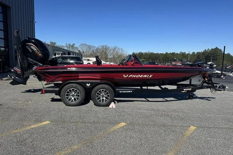 The Image of 2026 Phoenix 20 XE boat on trailer, parked outdoors under clear blue sky. - 1
