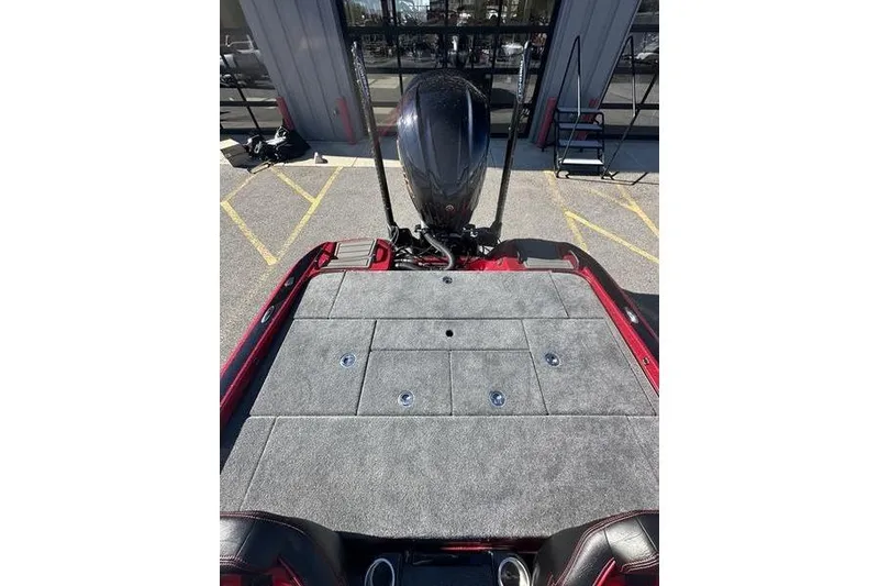 Slide: The Image of 2026 Phoenix 20 XE boat deck with motor, parked outside a building. - 3