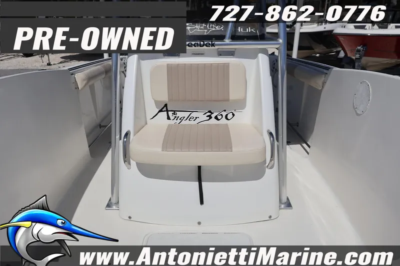Slide: The Image of Pre-owned 2004 Aquasport 205 Osprey boat interior with seating, contact details, and website. - 12
