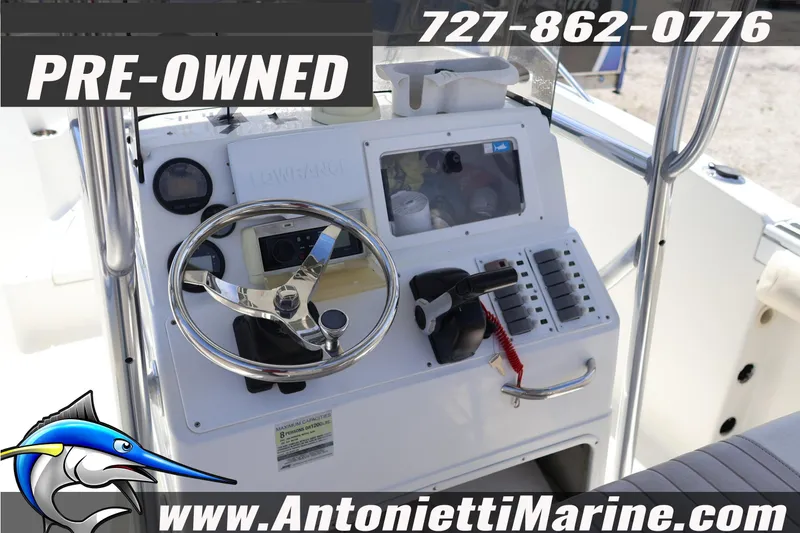 Slide: The Image of Pre-owned 2004 Aquasport 205 Osprey boat dashboard with steering wheel and controls. - 18