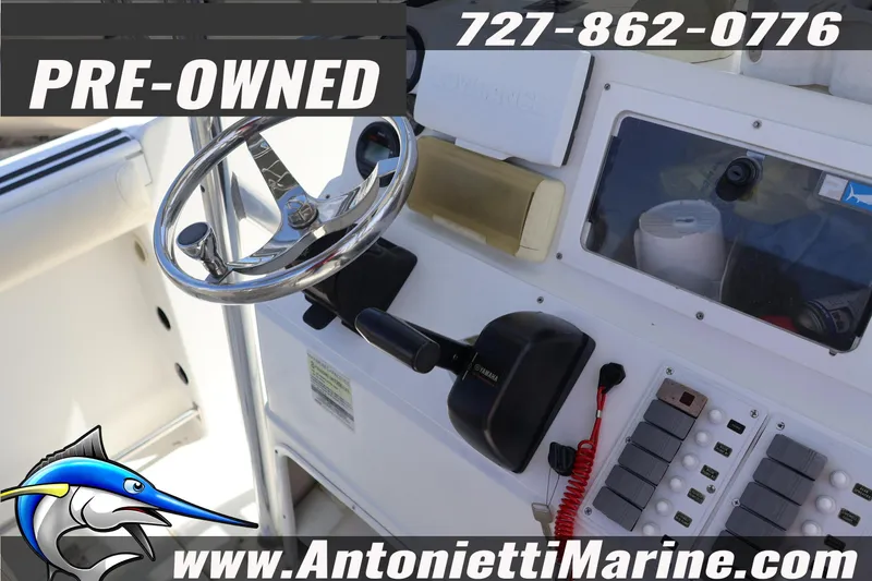 Slide: The Image of Pre-owned 2004 Aquasport 205 Osprey boat dashboard with steering wheel and controls. - 21