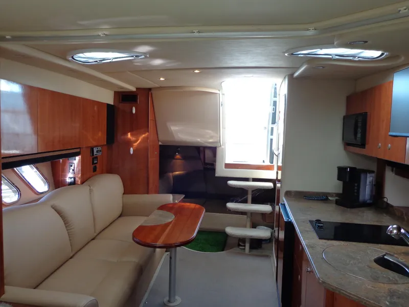 Slide: The Image of 2008 Cruisers Yachts 330 Express interior with sofa, table, and kitchenette. - 17