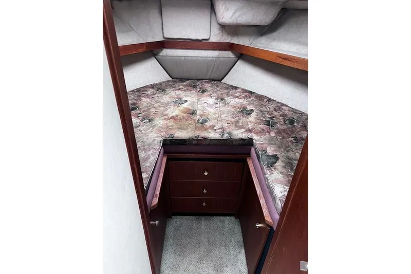 Slide: The Image of 1996 Bayliner 3388 Command Bridge Motoryacht cabin with floral bedding and wooden drawers. - 10