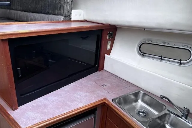 Slide: The Image of 1996 Bayliner 3388 Command Bridge Motoryacht interior kitchen with sink and microwave. - 13