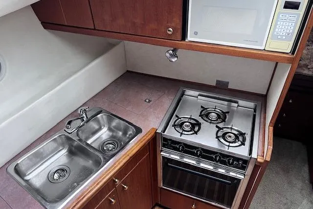 Slide: The Image of 1996 Bayliner 3388 Command Bridge Motoryacht kitchen with stove, sink, and microwave. - 14