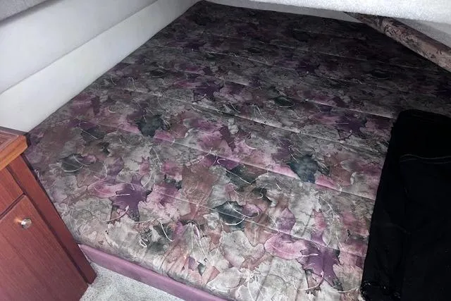 Slide: The Image of 1996 Bayliner 3388 Command Bridge Motoryacht interior with floral-patterned bed and wooden cabinet. - 8