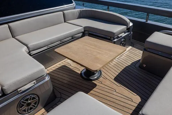 Slide: The Image of Luxurious seating area on 2025 Pershing GTX 80 yacht with wooden table and ocean view. - 13