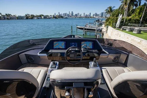 Slide: The Image of Cockpit view of 2025 Pershing GTX 80 yacht with city skyline in background. - 21