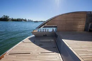 Slide: The Image of Luxury Pershing GTX 80 yacht deck, 2025 model, with sleek wooden finish and scenic water view. - 5