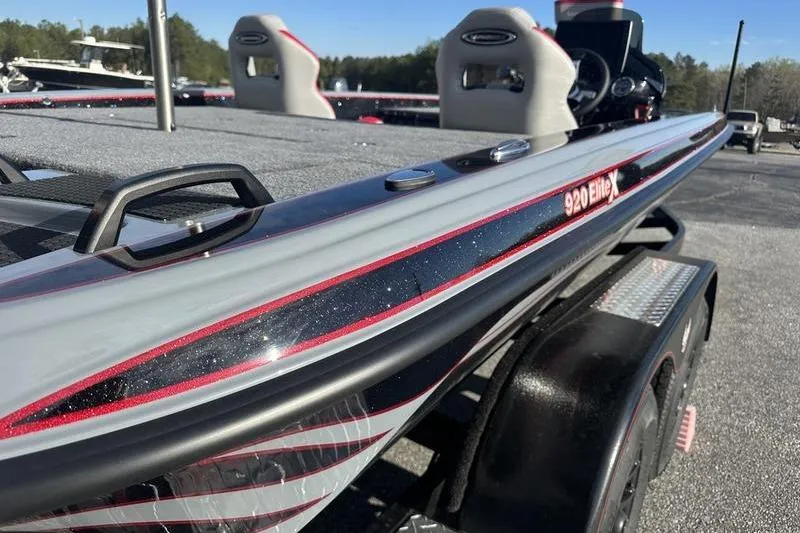 Slide: The Image of 2026 Phoenix 921 Elite X boat, sleek design with red accents, parked outdoors. - 4