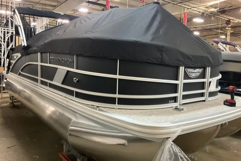 Slide: The Image of 2026 Bennington 22 MFB pontoon boat with cover in a warehouse setting. - 3