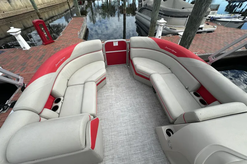 Slide: The Image of 2022 South Bay Pontoons 24 LE Series Tri Hull with red and beige seating at dock. - 11