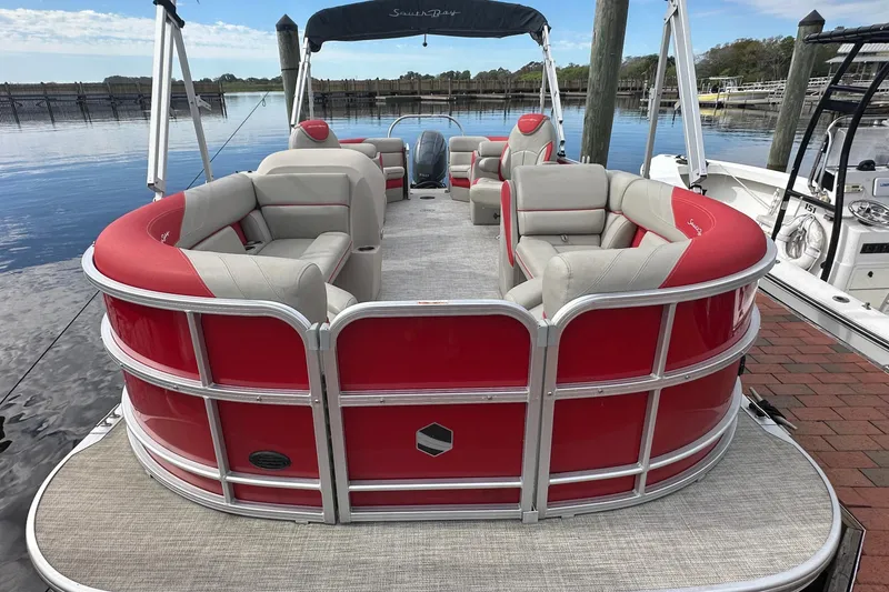 Slide: The Image of 2022 South Bay Pontoons 24 LE Series Tri Hull with red and gray seating at dock. - 4