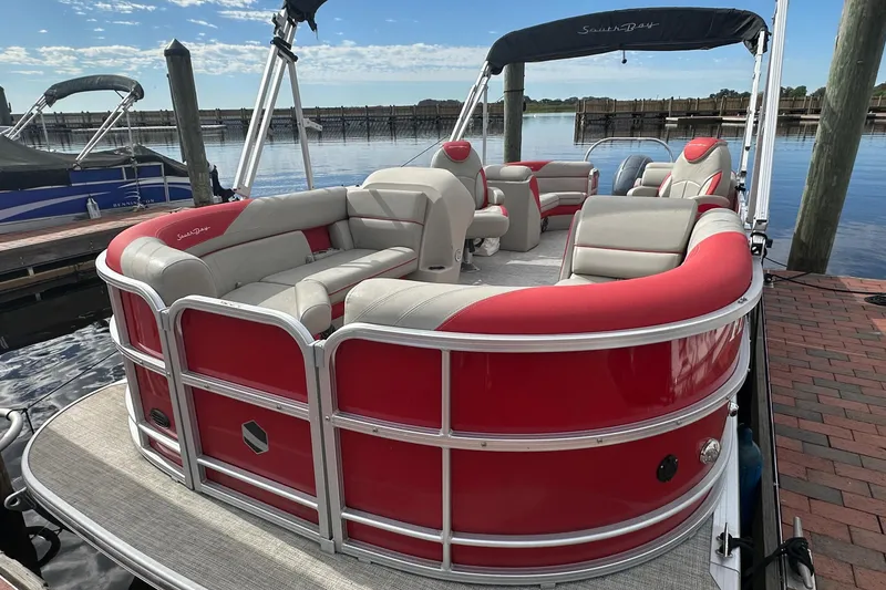 Slide: The Image of 2022 South Bay Pontoons 24 LE Series Tri Hull, red and white, docked by the water. - 5
