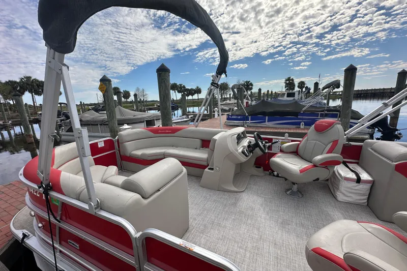 Slide: The Image of 2022 South Bay Pontoons 24 LE Series Tri Hull at marina, featuring red and white seating. - 8