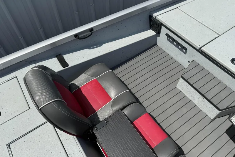 Slide: The Image of 2018 Ranger RT188 boat interior with red and black seat, gray flooring, and storage compartments. - 13