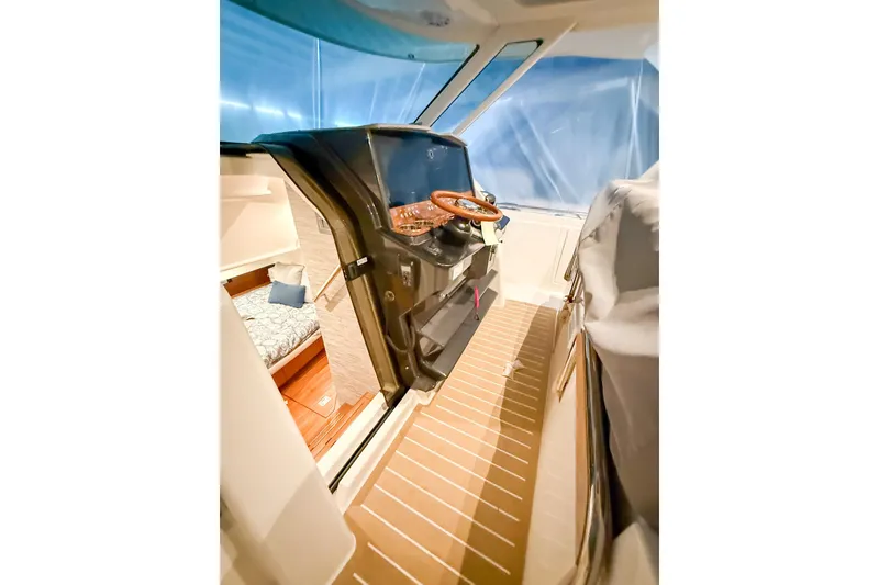 Slide: The Image of Interior view of 2025 Tiara Yachts 38 LS, featuring helm and cabin area. - 16