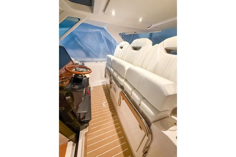 Slide: The Image of Interior of 2025 Tiara Yachts 38 LS with luxurious white seating and wooden accents. - 17