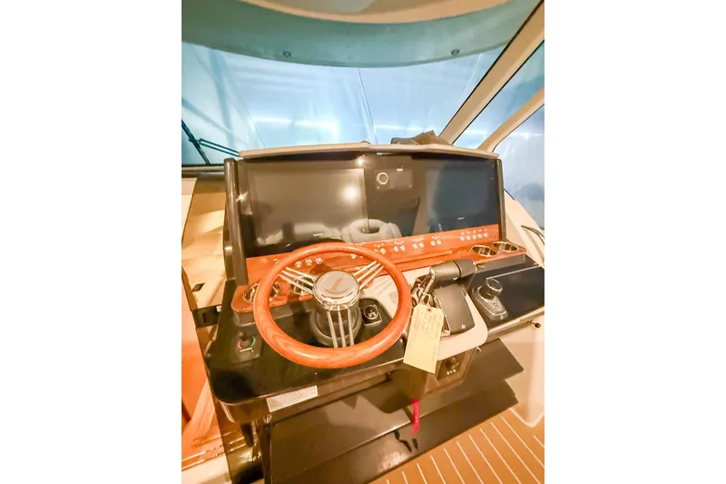 Slide: The Image of Helm of 2025 Tiara Yachts 38 LS with wooden steering wheel and modern controls. - 19
