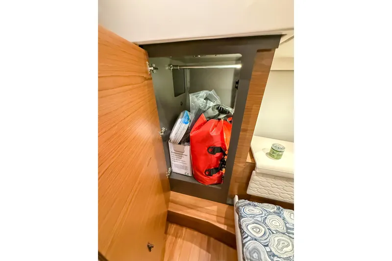 Slide: The Image of Storage cabinet on 2025 Tiara Yachts 38 LS, containing safety gear and supplies. - 26
