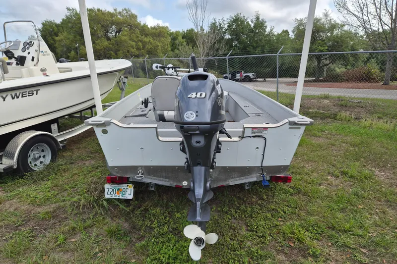Slide: The Image of 2018 Smoker Craft Angler 16 SC boat with outboard motor, parked on grass. - 11