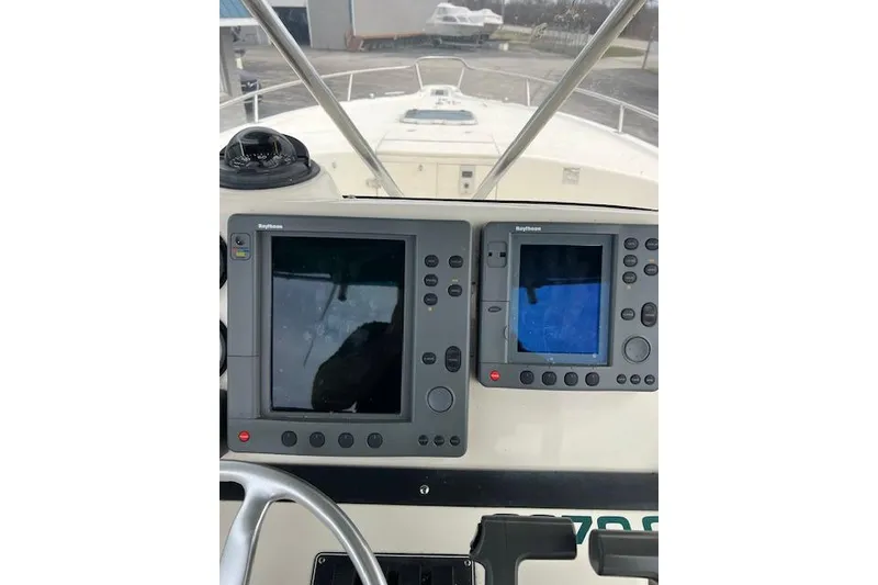 Slide: The Image of 2001 Pursuit 2670 Cuddy Console boat dashboard with navigation screens and compass. - 10