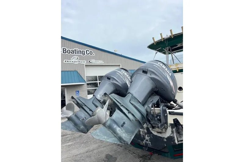 Slide: The Image of Twin Yamaha outboard motors on a 2001 Pursuit 2670 Cuddy Console boat at a dealership. - 14