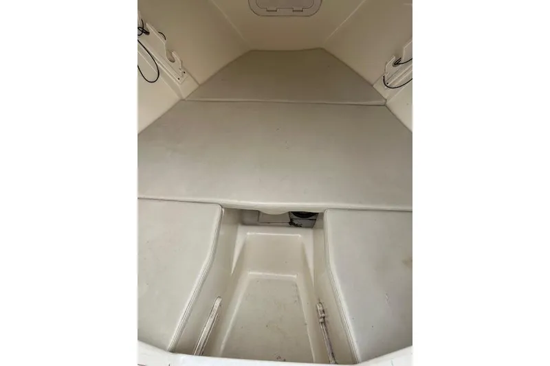 Slide: The Image of 2001 Pursuit 2670 Cuddy Console interior with cushioned seating and storage space. - 3