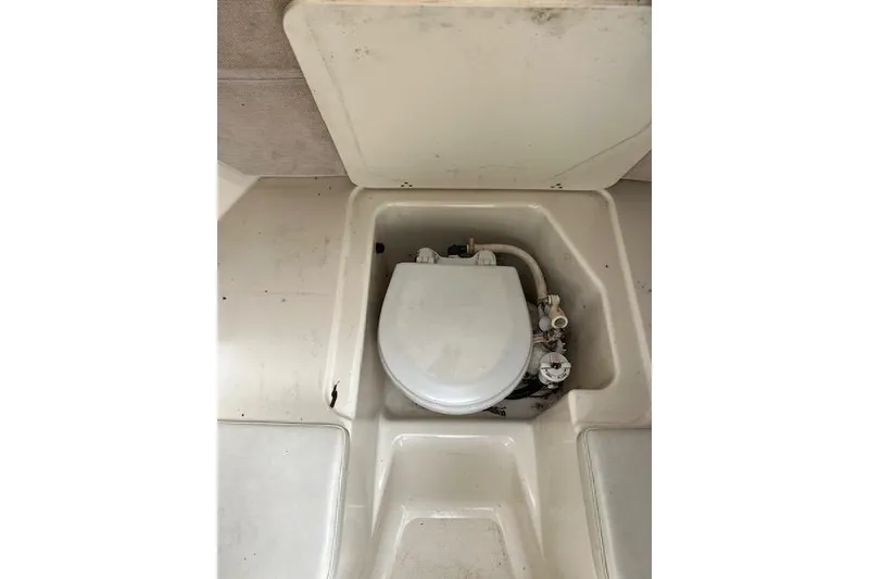 Slide: The Image of 2001 Pursuit 2670 Cuddy Console boat toilet compartment, white interior. - 4