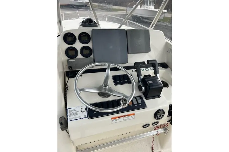 Slide: The Image of 2001 Pursuit 2670 Cuddy Console boat dashboard with steering wheel and controls. - 9