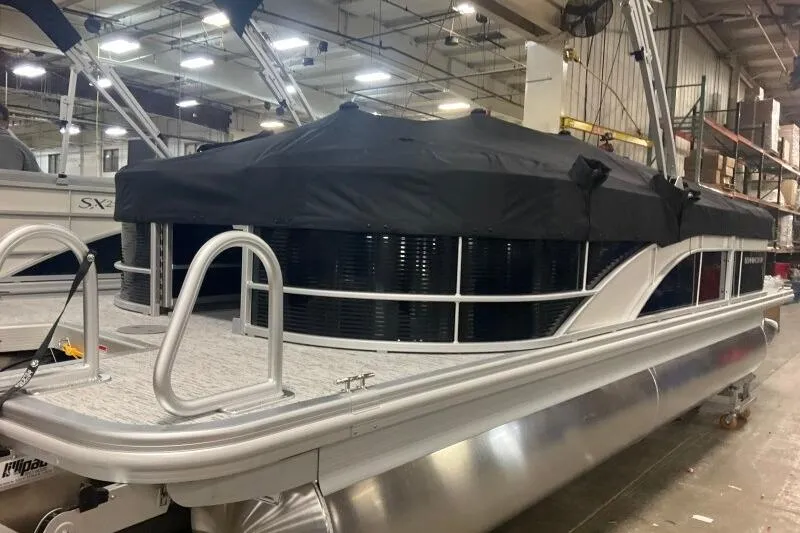 Slide: The Image of 2026 Bennington 22SXSR pontoon boat with black cover in a warehouse setting. - 6