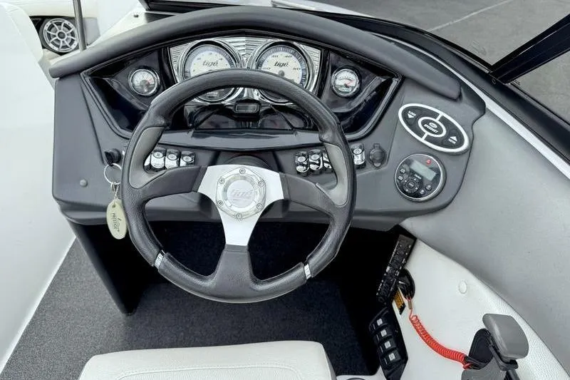 Slide: The Image of 2014 Tigé R20 boat dashboard with steering wheel and control panel. - 13