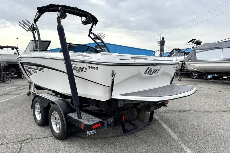 Slide: The Image of 2014 Tigé R20 boat on trailer, parked outdoors, showcasing sleek design and dual-axle trailer. - 3