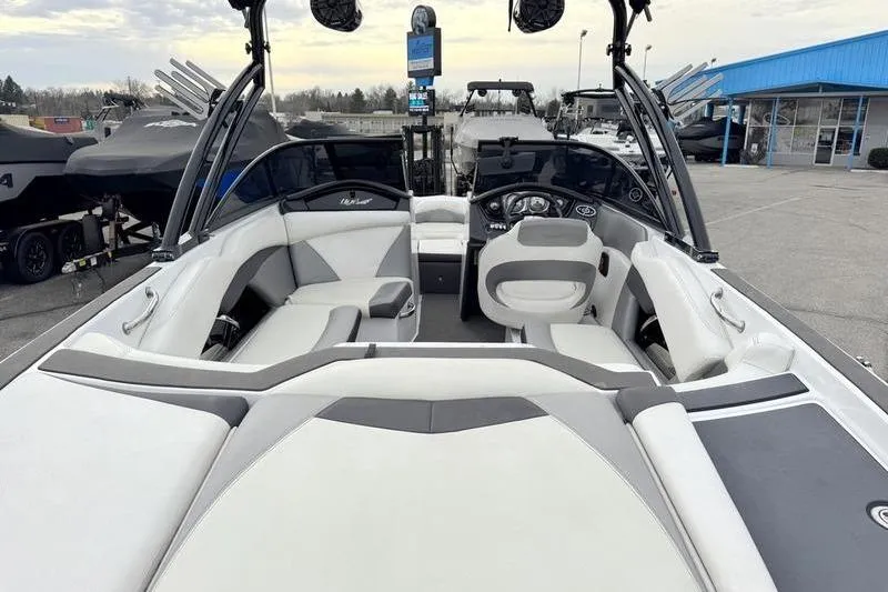 Slide: The Image of 2014 Tigé R20 boat interior with gray and white seating, parked at a marina. - 8