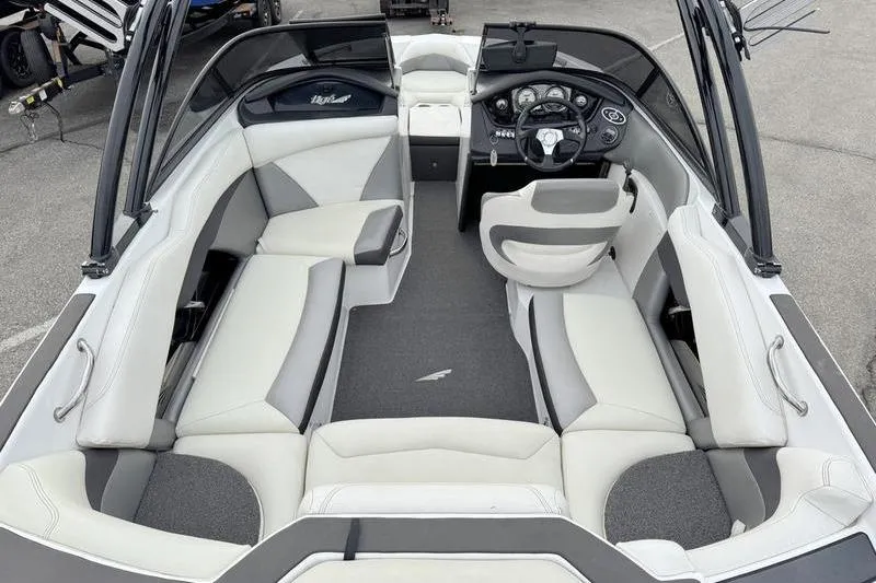 Slide: The Image of 2014 Tigé R20 boat interior with gray and white seating, steering console, and spacious layout. - 9