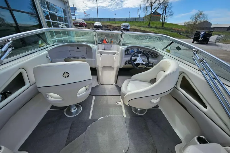 Slide: The Image of Interior of a 2011 Bryant 210 boat with white seating and steering wheel. - 11
