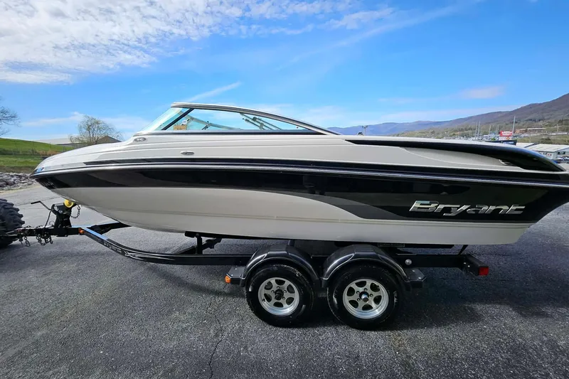Slide: The Image of 2011 Bryant 210 boat on trailer under a clear blue sky. - 12