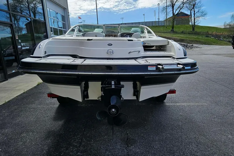 Slide: The Image of 2011 Bryant 210 boat rear view, parked outdoors near a building. - 3