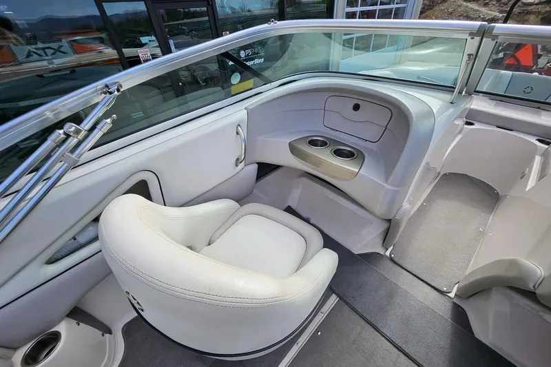 Slide: The Image of Interior of a 2011 Bryant 210 boat featuring white seating and cup holders. - 6