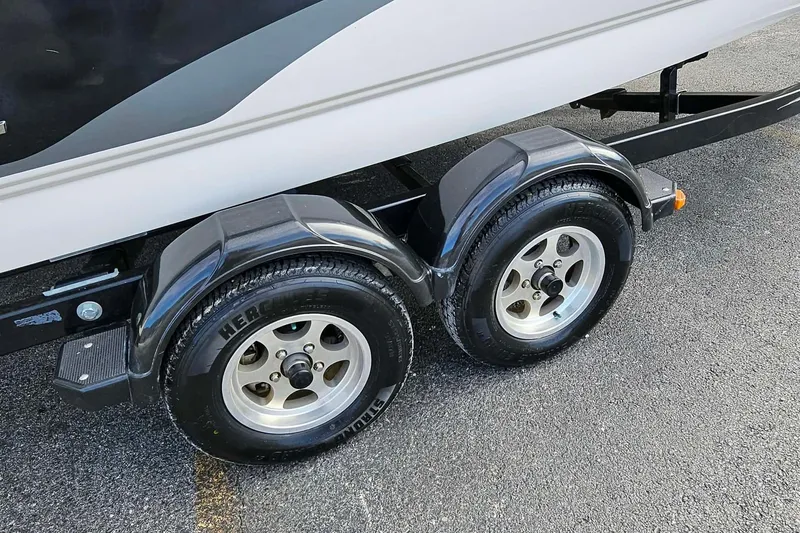 Slide: The Image of Trailer wheels of a 2011 Bryant 210 boat on asphalt surface. - 8