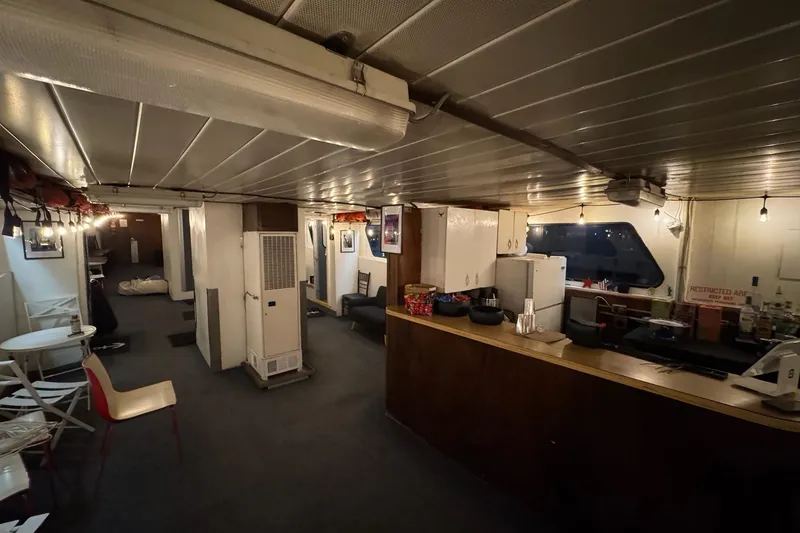 Slide: The Image of Interior of a 1985 Custom Commercial Steel 100 ship with seating and bar area. - 10