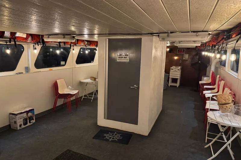 Slide: The Image of Interior of a 1985 Custom Commercial Steel 100 boat with seating and life jackets. - 11