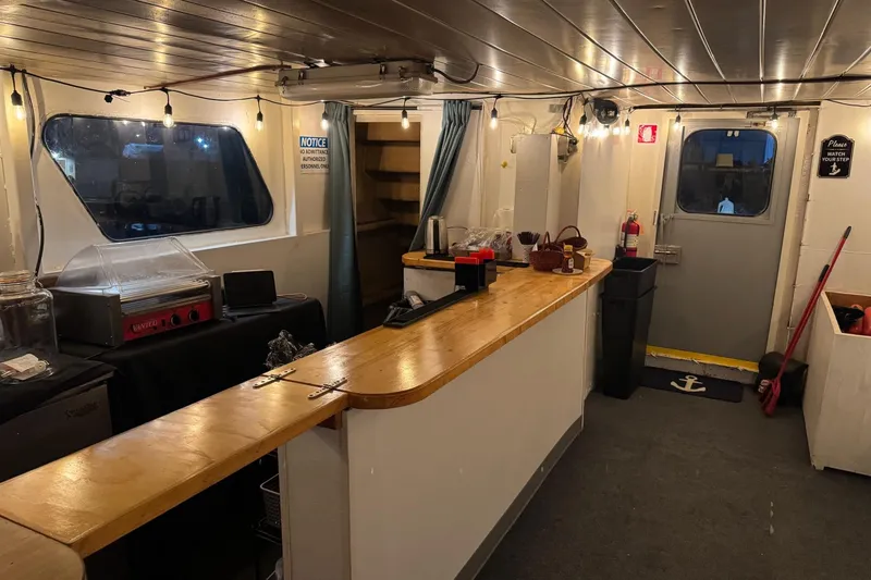 Slide: The Image of Interior of a 1985 Custom Commercial Steel 100 ship with a wooden counter and kitchen equipment. - 12