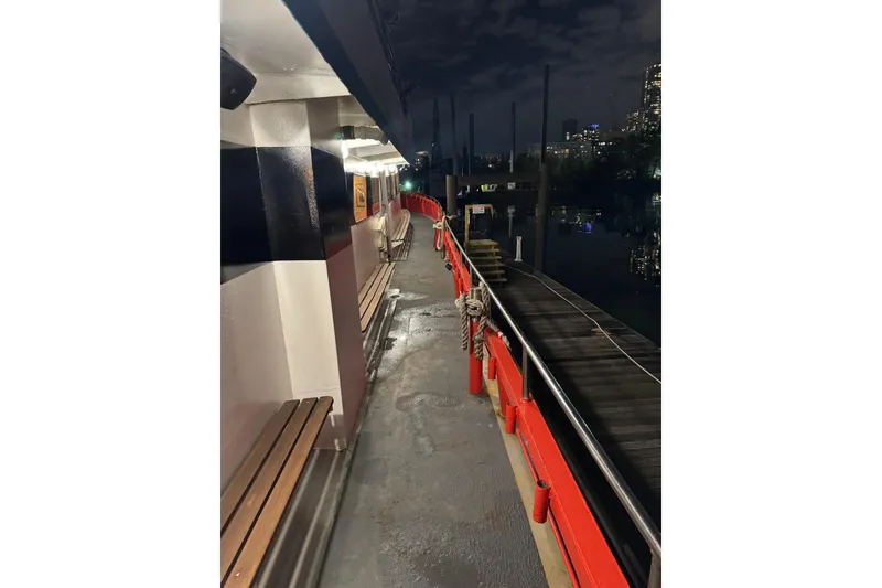 Slide: The Image of Nighttime view of a docked Custom Commercial Steel 100 boat, built in 1985. - 13