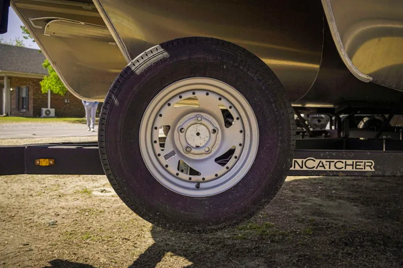 Slide: The Image of Close-up of a 2025 SunCatcher Fusion 324SS trailer wheel on a sunny day. - 10