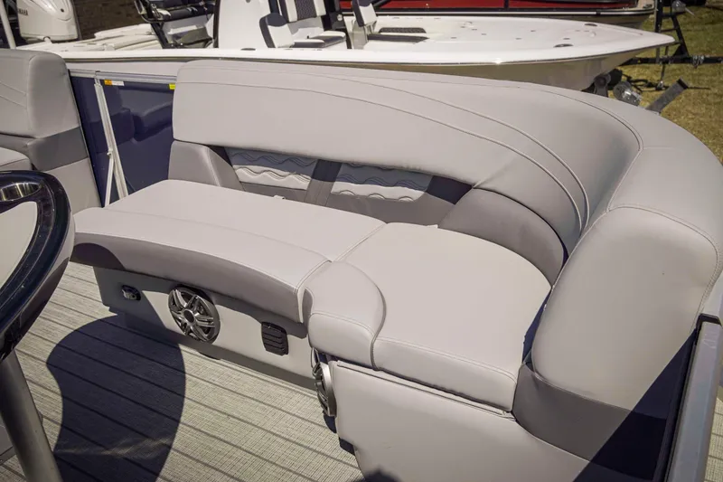 Slide: The Image of 2025 SunCatcher Fusion 324SS boat interior with plush seating and integrated speaker system. - 16