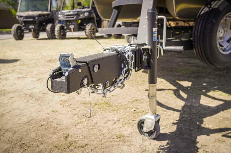 Slide: The Image of Trailer hitch of 2025 SunCatcher Fusion 324SS with safety chains and wheel jack. - 9