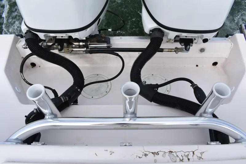 Slide: The Image of 2001 Grady-White Advance 247 boat engine area with dual motors and rod holders. - 22