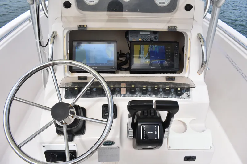 Slide: The Image of Control panel of a 2001 Grady-White Advance 247 boat with steering wheel and navigation equipment. - 24
